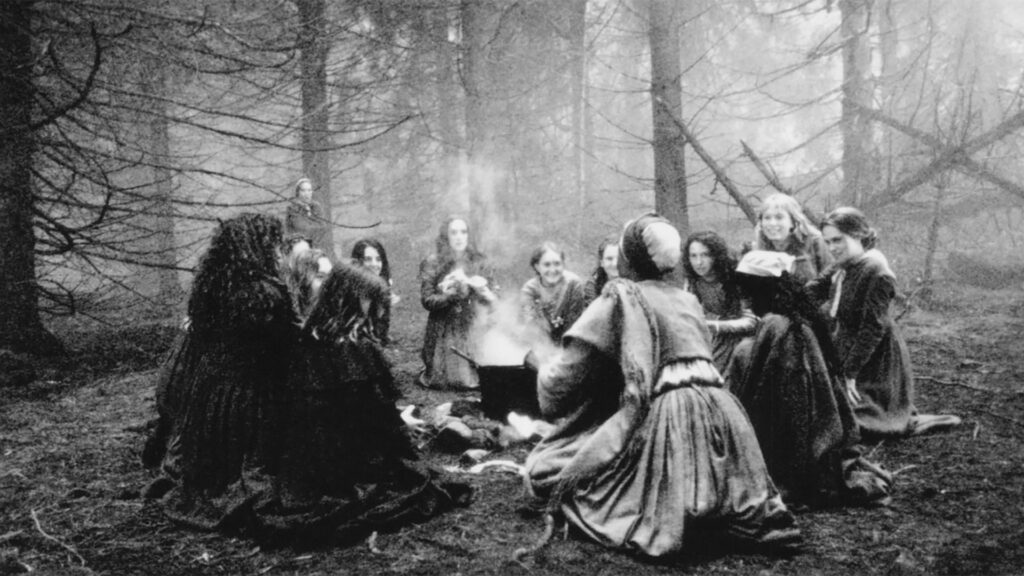 Film still from The Crucible (1996) showing Winona Ryder and Charlayne Woodard, dramatizing fear and scapegoating in colonial Salem.